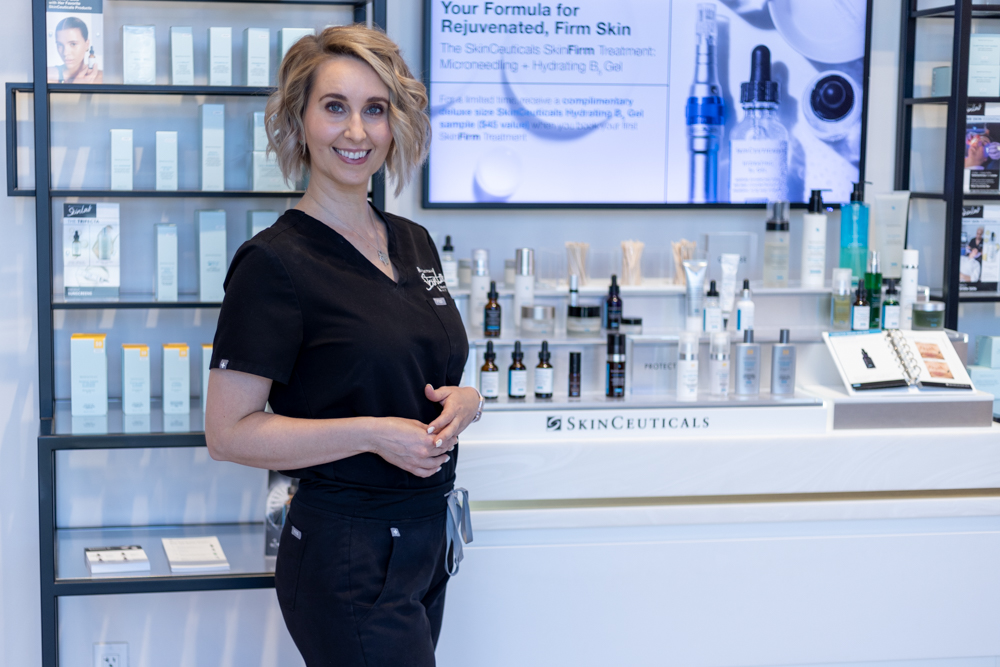 Esthetician posed in front of product counter